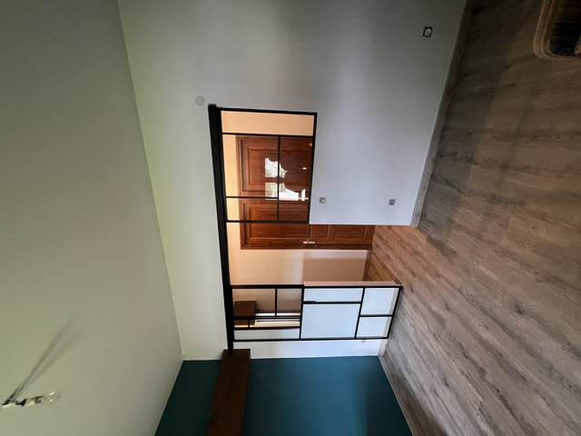Verrière métallique atelier séparant le séjour de l'entrée, mur bleu canard et parquet — Lyon